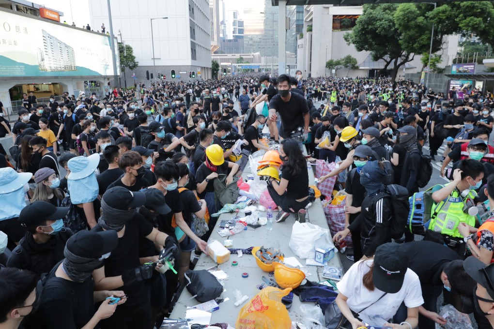 Extradition bill protesters passing helmets and other material on Harcourt Road in Admiralty on July 21. Photo: Edmond So