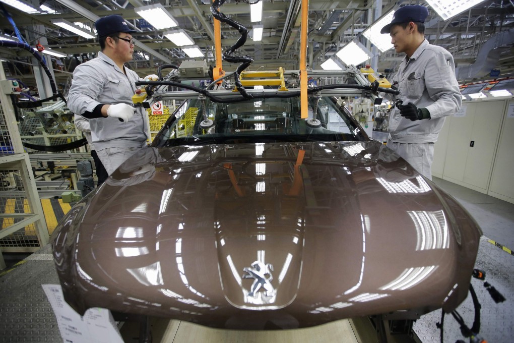 Workers on a production line at Dongfeng Peugeot Citroen Automobile in Wuhan, Hubei province on February 13, 2014. Photo: Reuters