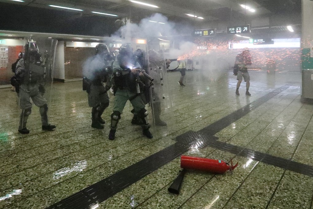 Riot police officers use tear gas inside Kwai Fong MTR station, the first time it has been used within the MTR network. Photo: Felix Wong