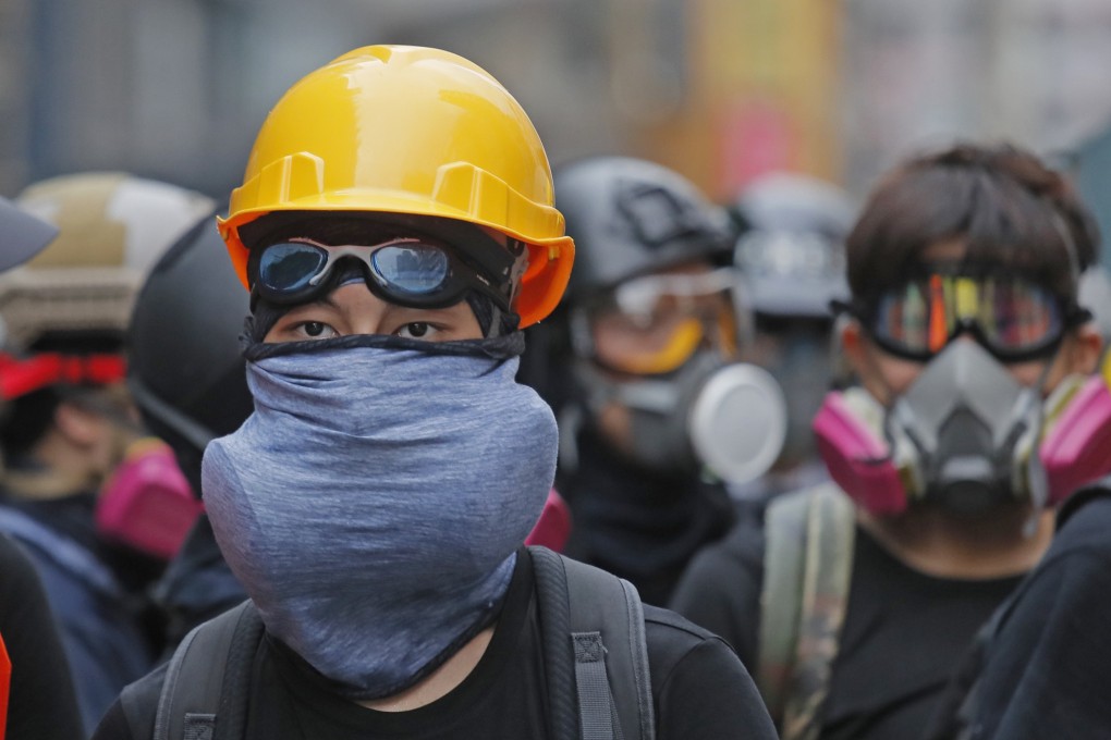 Protesters in protective gear face riot police on August 11. Photo: AP