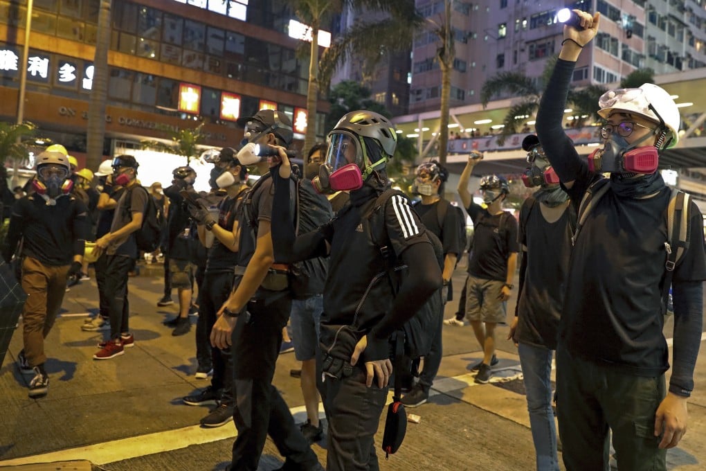 Protesters with protection gear face riot police in Hong Kong. Photo: AP