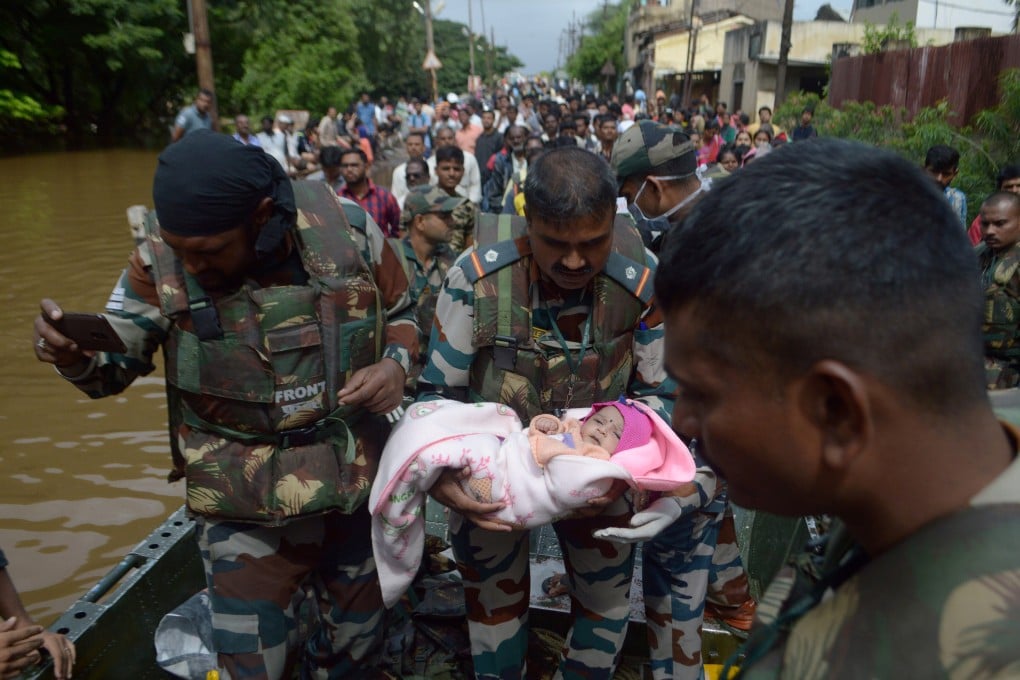 A soldier carries an infant as they evacuate flood-affected people in Sangli district in the western state of Maharashtra, India. Photo: Reuters