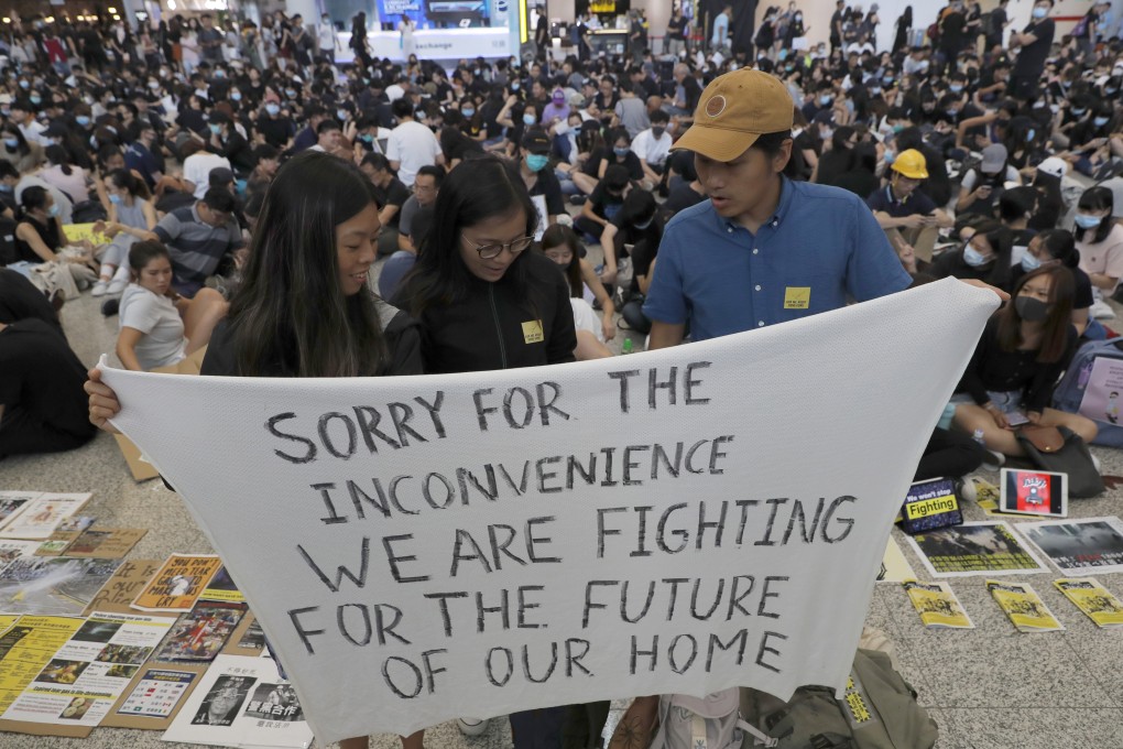 Protesters hold up a banner during a demonstration at the airport in Hong Kong on August 9. Pro-democracy activists rallied at the airport on Friday even as the city sought to reassure visitors of their welcome despite increasing levels of violence. Photo: AP