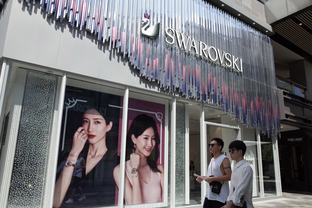 People walk past a Swarovski store in Beijing on Monday. Photo: EPA-EFE