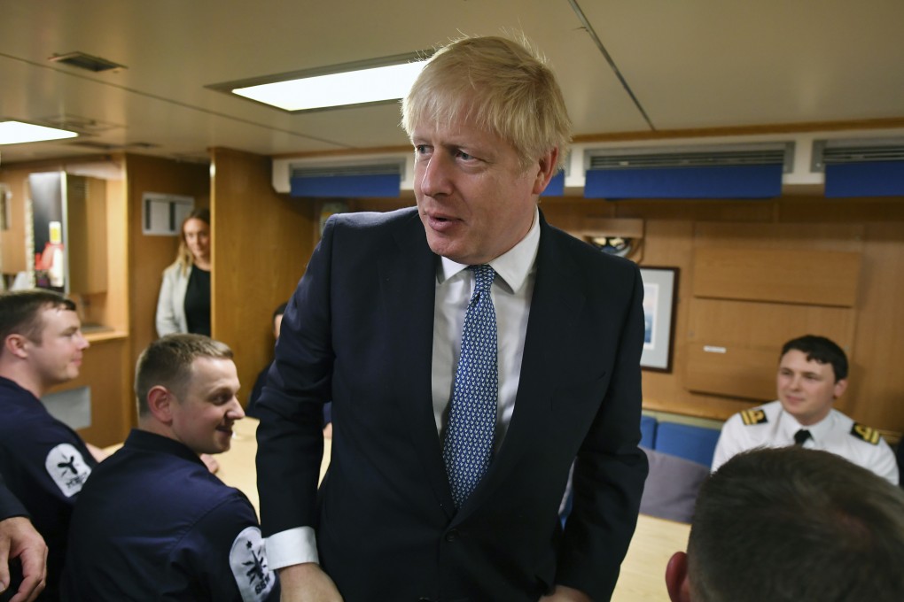 British Prime Minister Boris Johnson meets crew members as he tours the nuclear submarine HMS Victorious at the naval base in Faslane, Scotland on July 29. Johnson has insisted that the UK will proceed with exiting the European Union this year despite unanswered questions about how this will take place. Photo: AP