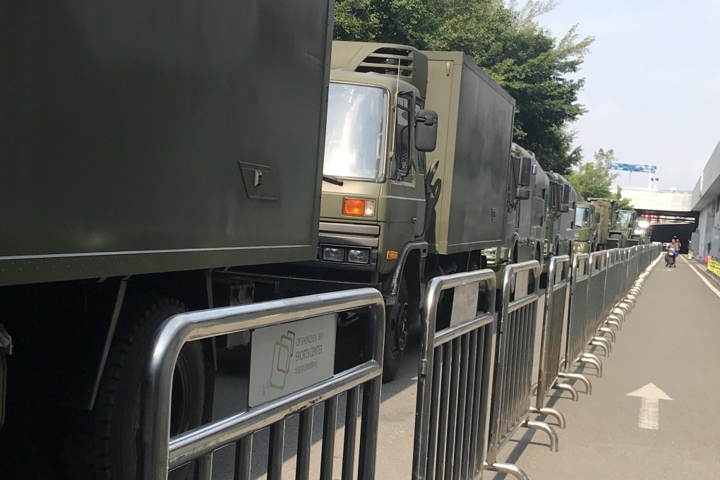 Dozens of trucks line a street next to the entrance of the Shenzhen Bay Sports Centre in Shenzhen on Monday. Photo: SCMP