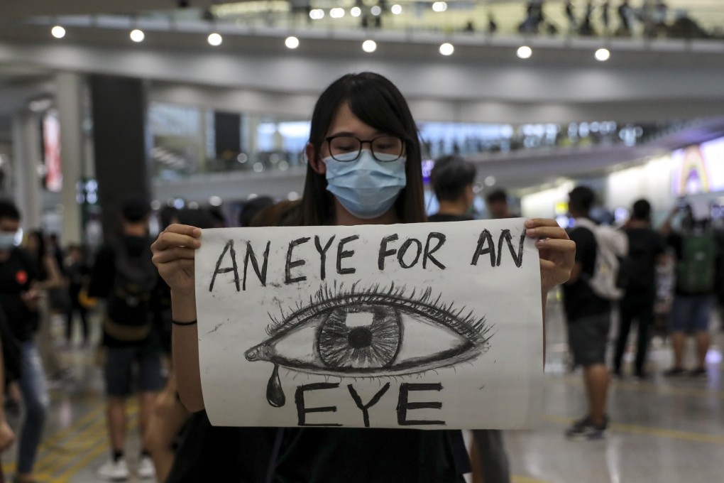 An anti-government protester makes her feelings known in the arrivals hall at Hong Kong International Airport on Monday. Photo: Sam Tsang