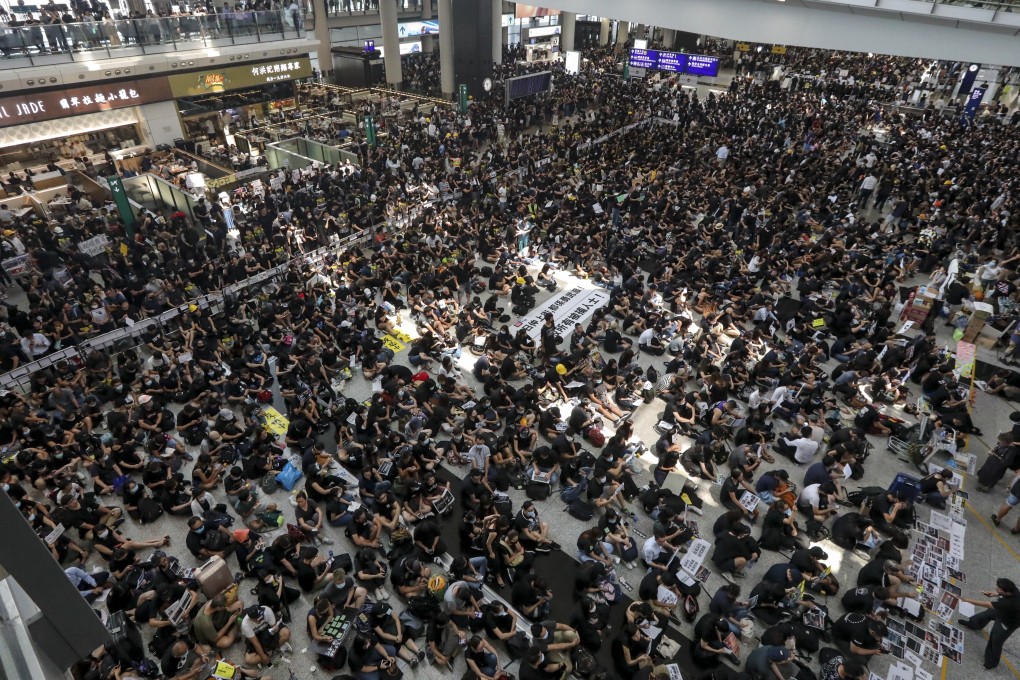 Protesters hold a sit-in at Hong Kong International Airport on Monday. As many as 272 flights were cancelled in two days of protests. Photo: Felix Wong