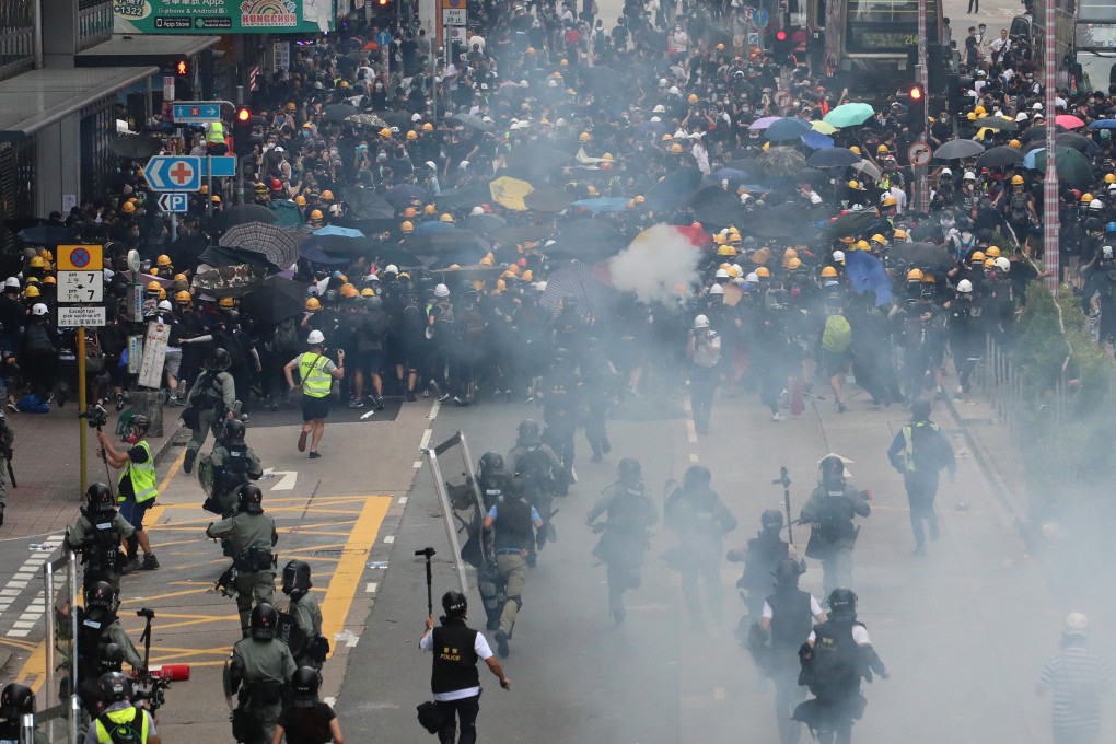 A group of riot police runs towards anti-government protesters, Sham Shui Po. Photo: Felix Wong