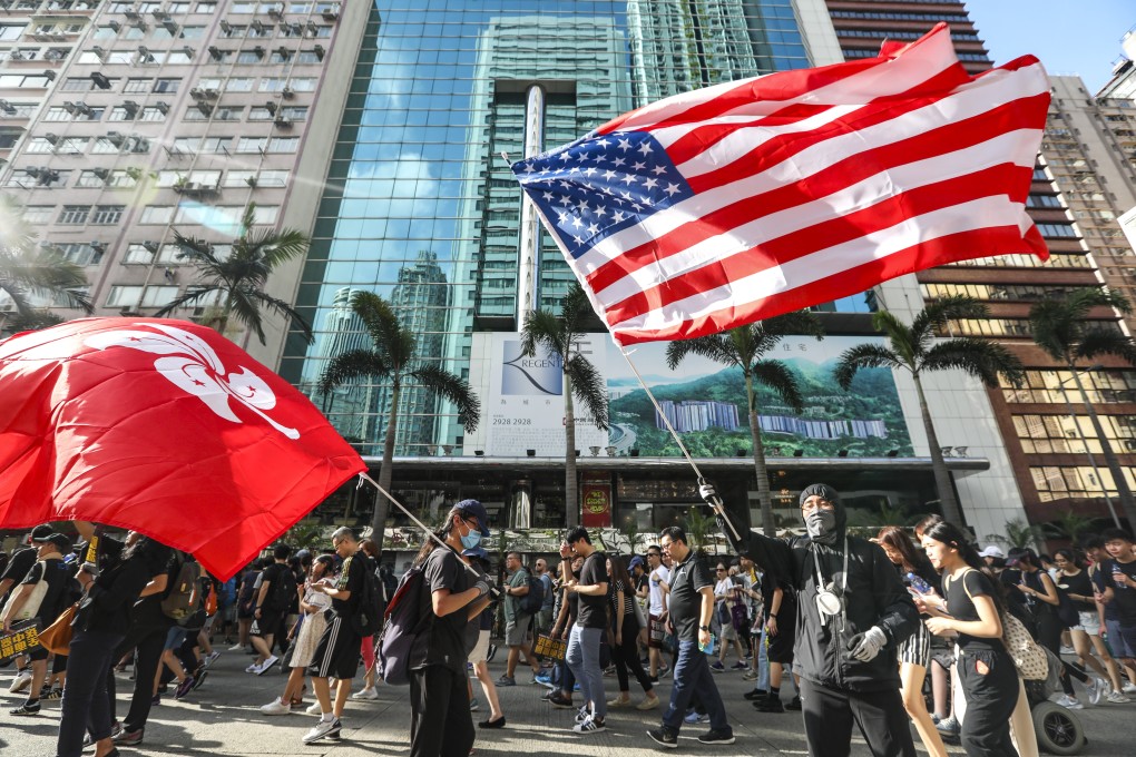 A protester holds a US flag during a march on Hong Kong Island last month. Photo: Xiaomei Chen