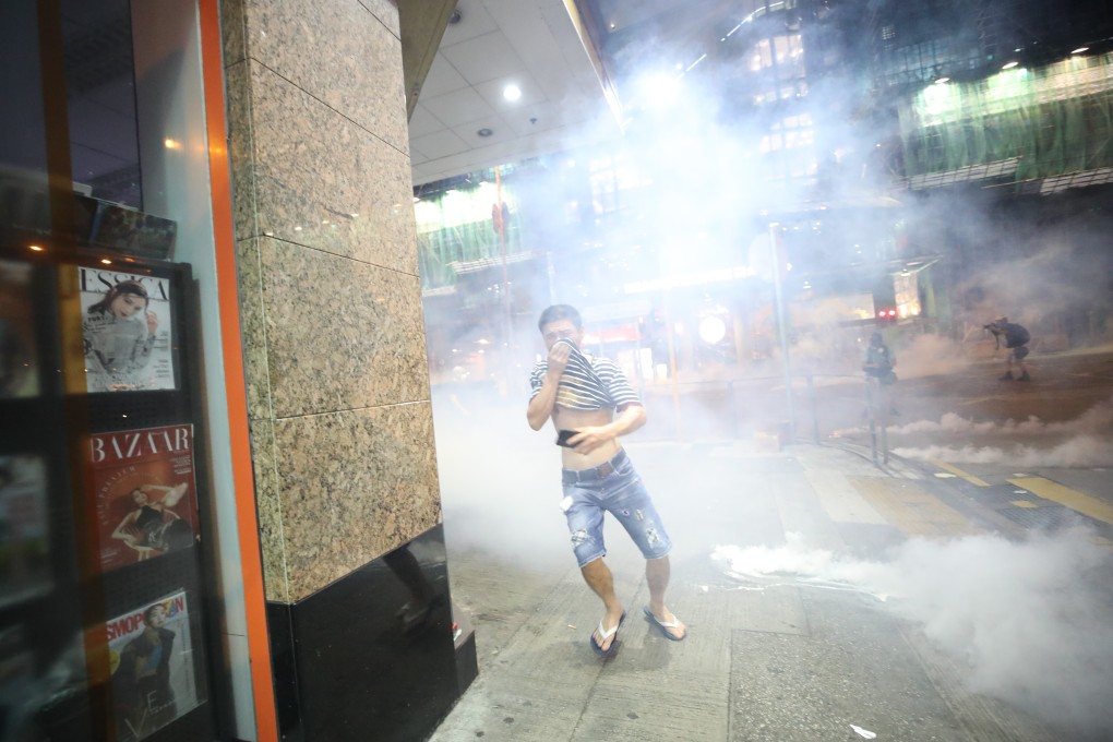 A bystander finds himself caught in cloud of tear gas fired by the police at protesters in Sham Shui Po on August 14. Photo: Winson Wong