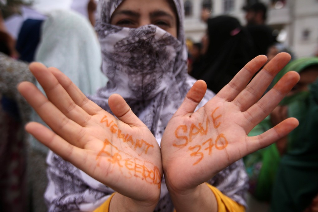 A Kashmiri woman shows messages written on her hands at a protest in Srinagar on Friday. Photo: Reuters