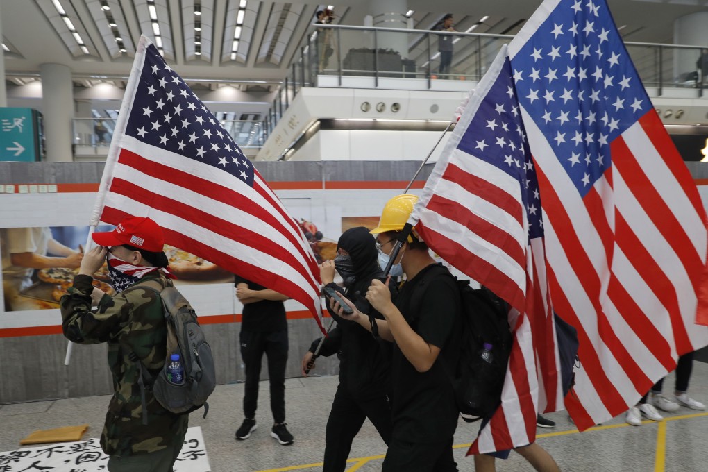 Anti-government protesters carry US flags during a demonstration at the Hong Kong International Airport on August 9. Photo: AP