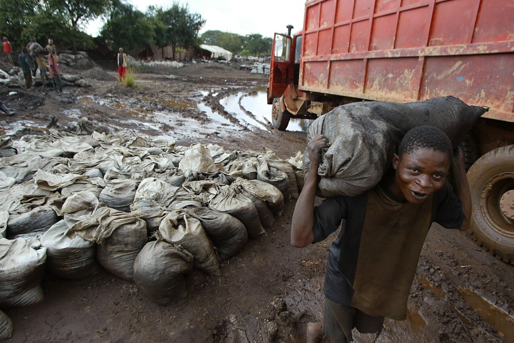 A worker carries wet cobalt on his back at a mine in the Democratic Republic of Congo. Photo: AP