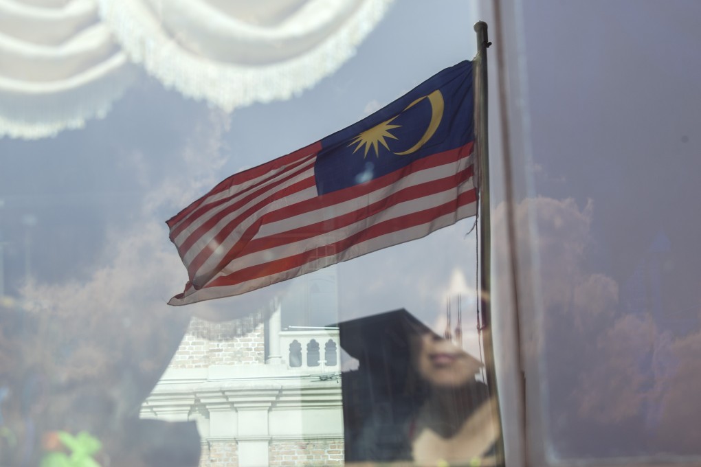 A Malaysian flag is reflected on a bus window in Kuala Lumpur. Photo: Bloomberg