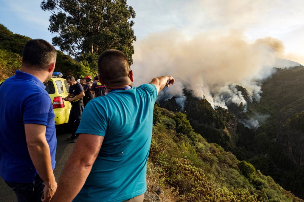 Residents observe the forest fire in the village of Valleseco, Gran Canaria island. Photo: EPA-EFE