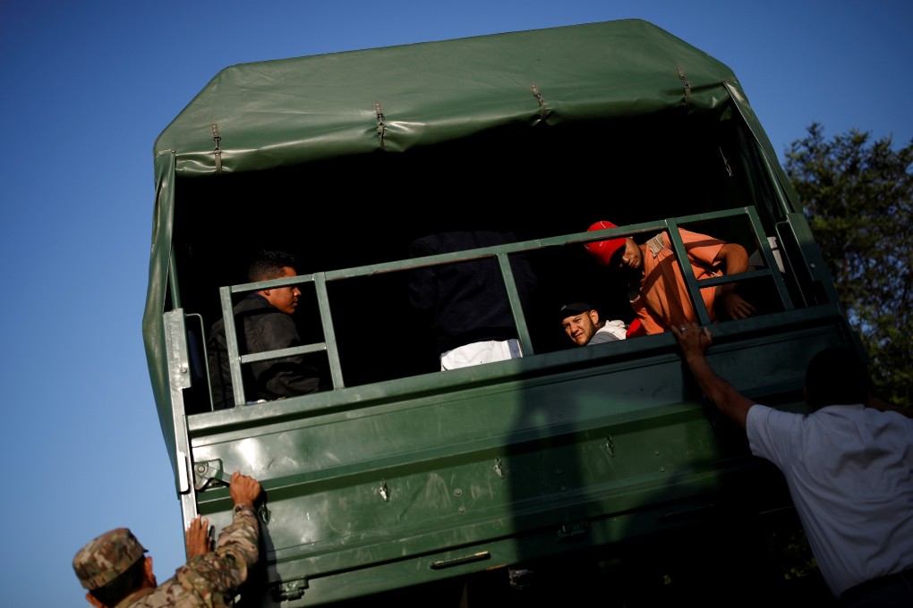 Venezuelan migrants get on military trucks to get a free ride from the Ecuadorian-Peruvian border service to Tumbes. Photo: Reuters