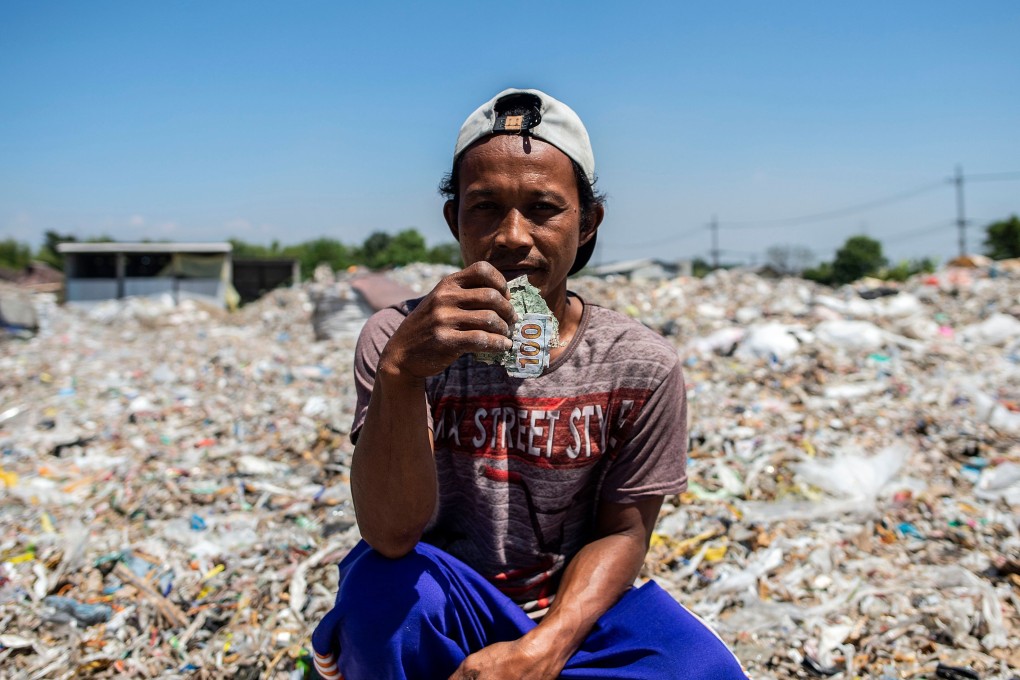 Villager Keman sitting amongst plastic waste in the village of Bangun, Indonesia. Photo: AFP