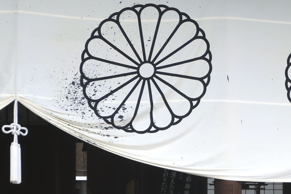 Police officers survey the vandalism at the Yasukuni Shrine. Photo: Kyodo