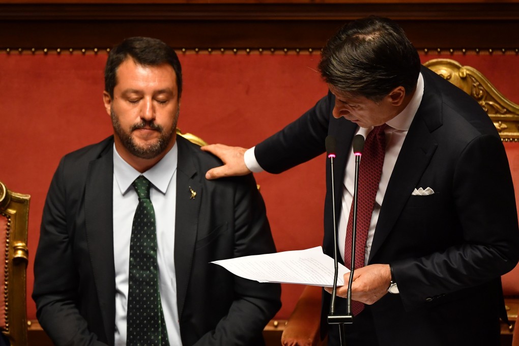 Italian Prime Minister Giuseppe Conte touches Deputy Prime Minister and Interior Minister Matteo Salvini's shoulder as he delivers a speech at the Italian Senate. Photo: AFP