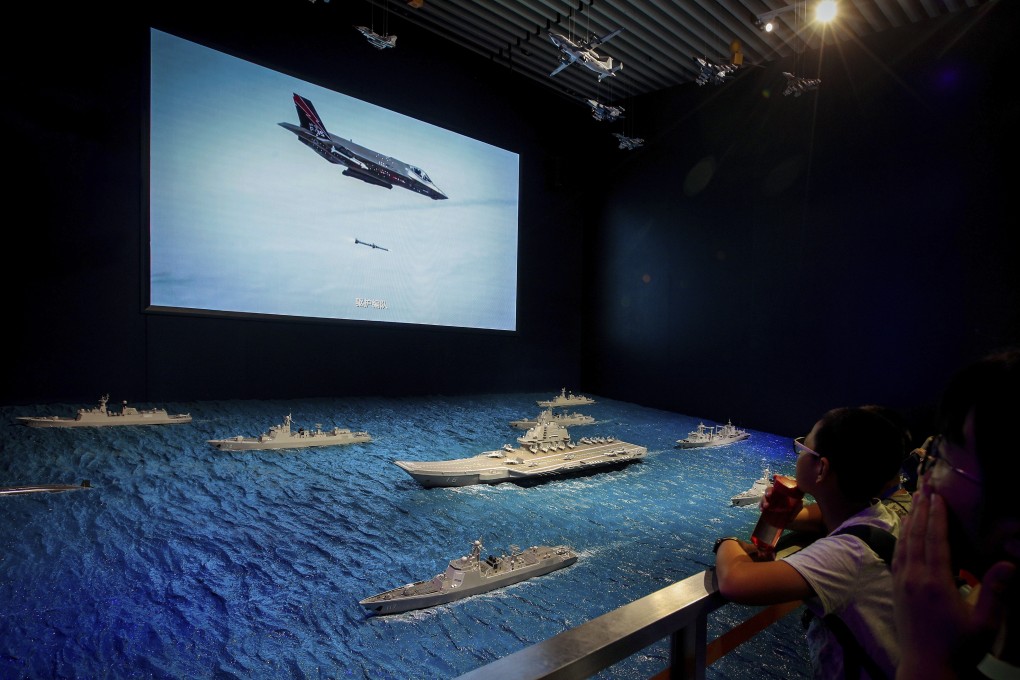 A US Air Force F-35 plane is shown on a TV screen firing a missile near the models of China’s Liaoning aircraft carrier, as part of an exhibit at the Military Museum in Beijing. The demise of the INF Treaty raises the spectre of a new arms race between the US and China. Photo: AP