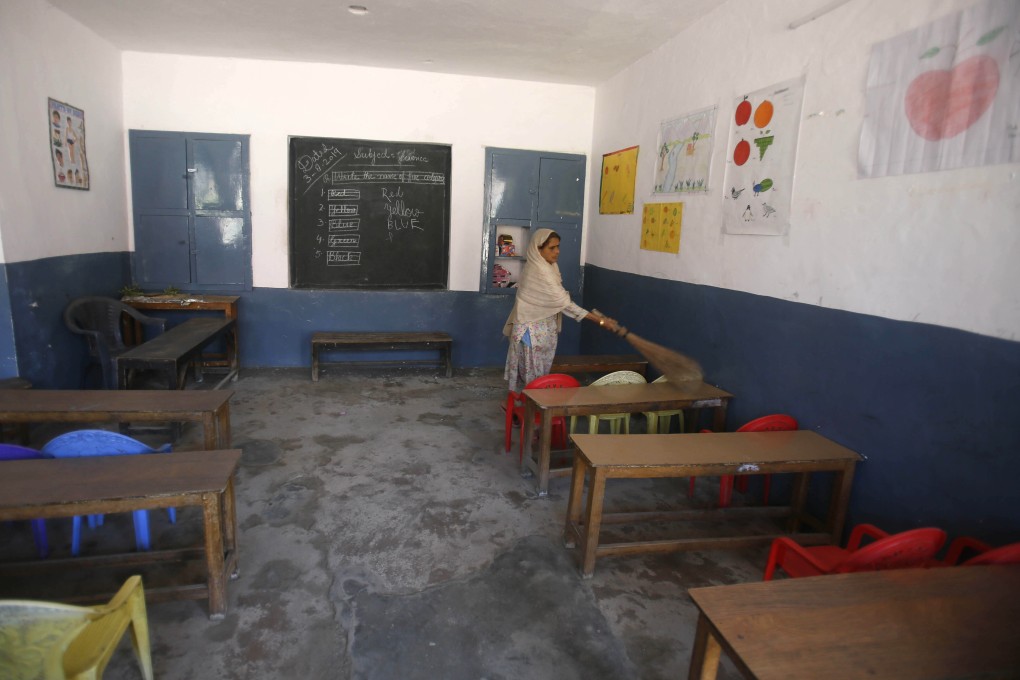A staff member cleans a deserted classroom in Srinagar on Monday. Photo: AP