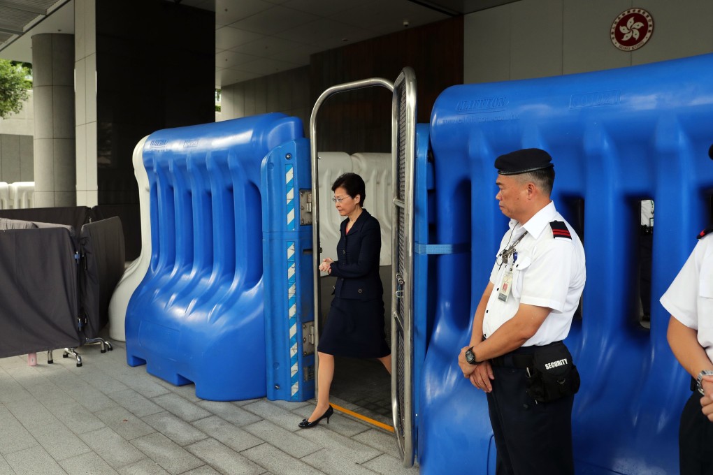 Chief Executive Carrie Lam Cheng Yuet-ngor walks through water barriers as she arrives for a media briefing ahead of her weekly Executive Council meeting, at the government headquarters in Tamar, Admiralty, on August 20. She pledged to create a “platform for dialogue” but once again dismissed calls for an independent inquiry into police conduct. Photo: Sam Tsang