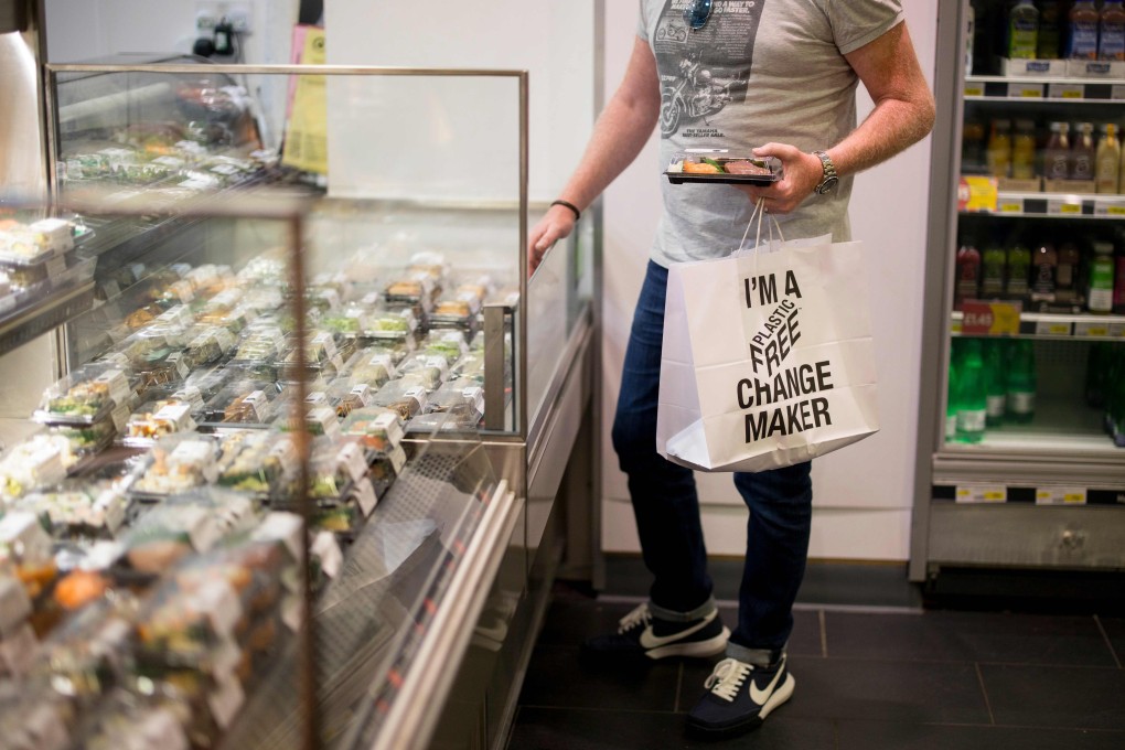 A shopper holds a paper bag with a slogan promoting plastic-free packaging at a supermarket in London. Photo: AFP