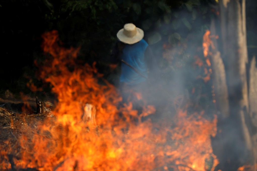 A man works in a burning tract of Amazon jungle as it is being cleared by loggers and farmers in Iranduba, Amazonas state, on Tuesday. Photo: Reuters
