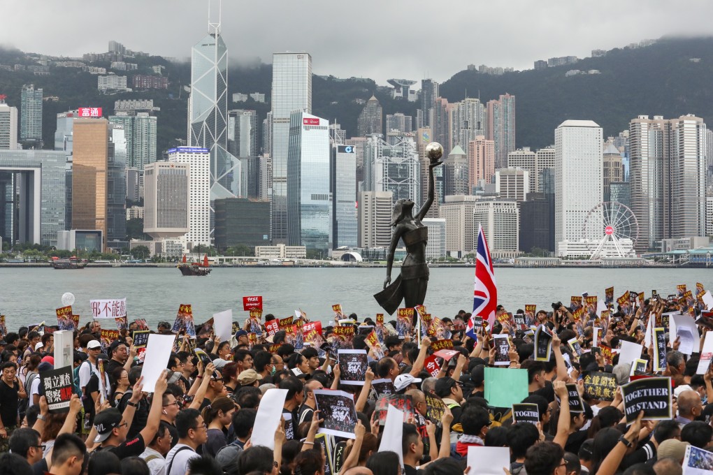 Protesters march past a view of the iconic Hong Kong skyline in Tsim Sha Tsui towards the West Kowloon high-speed rail terminus on July 7. Photo: Felix Wong