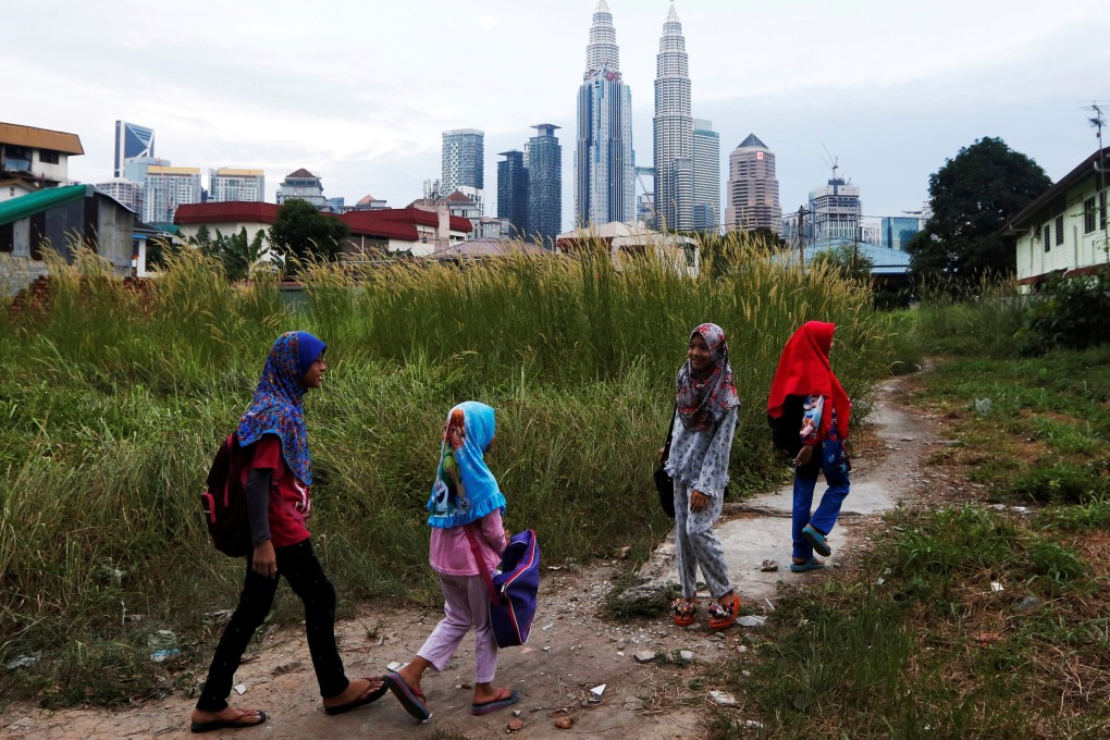 Girls make their way home after school in Kuala Lumpur, Malaysia. Photo: Reuters