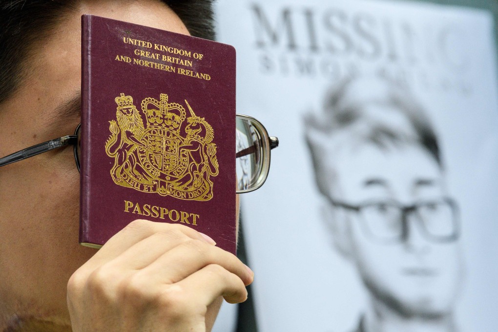 An activist holds a British passport outside Britain’s consulate in Hong Kong after news of Simon Cheng’s detention. Photo: AFP