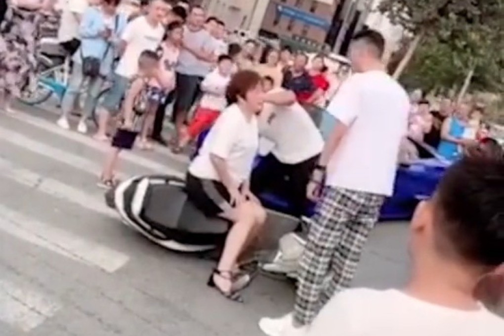 A blogger, his mother, and a friend with a camera pull the road accident stunt in Zhengzhou, Henan province, that was to end in detention and a fine for them all. Photo: Weibo