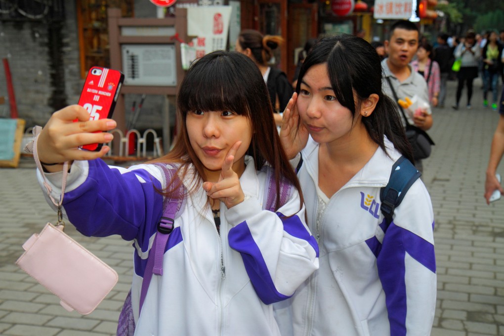 Students taking photos at Beijing’s Nanluo Guxiang historic street.