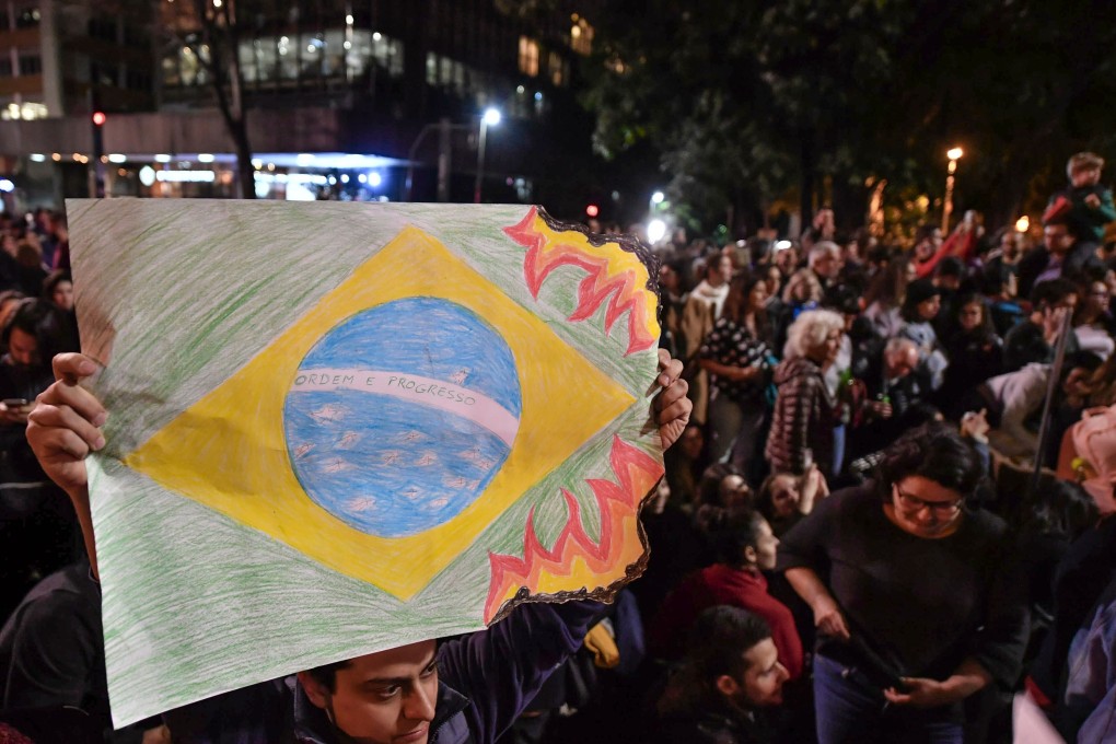People in Sao Paulo protest on Friday against Brazil’s President Jair Bolsonaro over the fires in the Amazon rainforest. Photo: AFP