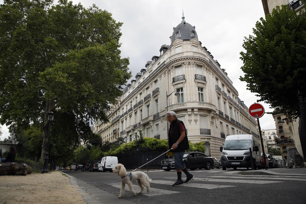 A man walks his dog across from Jeffrey Epstein’s apartment in the 16th district in Paris on August 13. Photo: AP