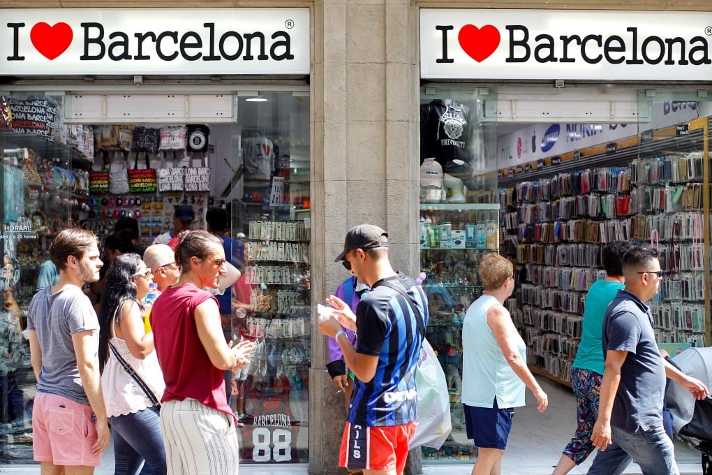 Tourists walk past a souvenir shop in downtown Barcelona, Spain on Friday. Photo: EPA