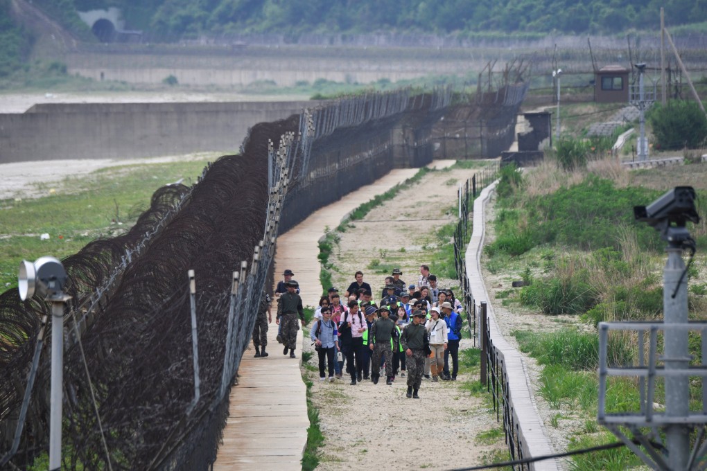 South Korean soldiers escort hikers along a fence in the DMZ. Photo: AFP