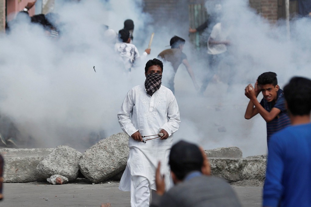 Kashmiris run for cover as smoke rises from tear gas shells fired by Indian security forces during clashes in Srinagar. Photo: Reuters