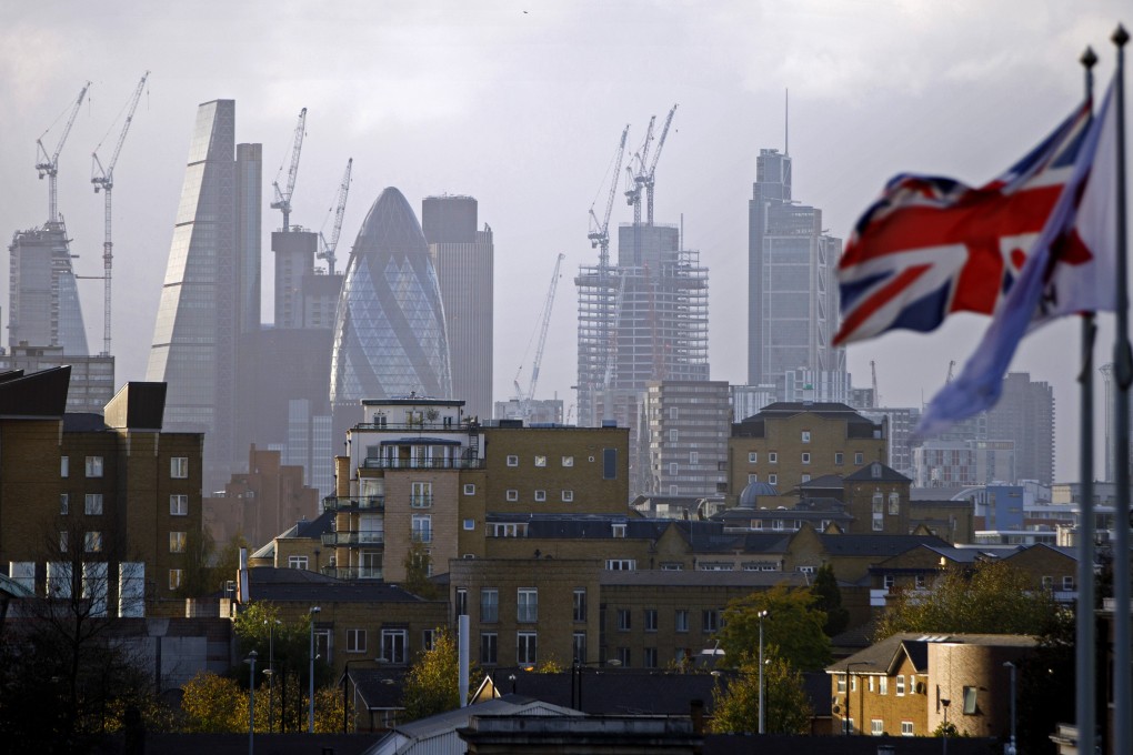 A Union flag flies from a pole in London, with skyscrapers in the background including the Leadenhall Building (second from left), commonly called the Cheesegrater. Photo: AFP