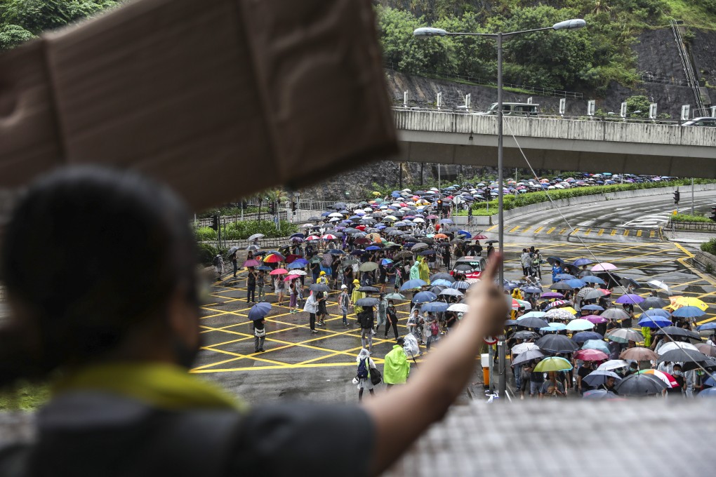 A woman cheers on protesters as they march from Kwai Chung Sports Ground to Tsuen Wan Park on August 25. Photo: Sam Tsang