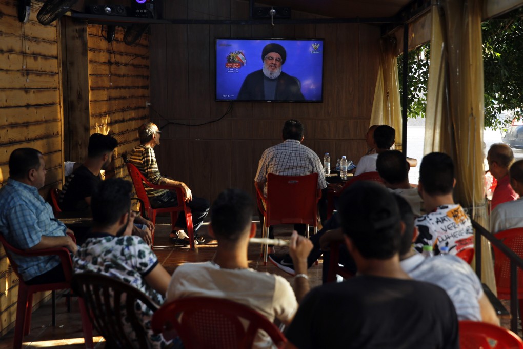 People listen to a speech by Hezbollah leader Sayyed Hassan Nasrallah being broadcast on Hezbollah's al-Manar TV channel. Photo: AP Photo