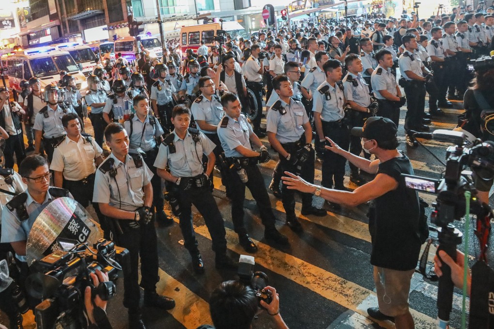 A man talks to police officers as protesters marching down Nathan Road from Tsim Sha Tsui arrive in Mong Kok on July 7. With the government unwilling to meet protesters’ demands and the protesters unwilling to back down, Hong Kong’s stand-off looks intractable. Photo: Dickson Lee