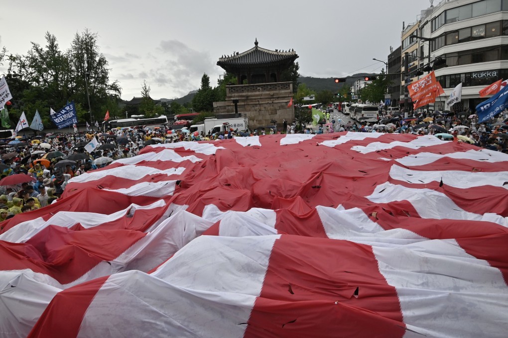 South Korean protesters tear a huge Japanese flag during a rally in Seoul on August 15 marking the anniversary of Korea’s liberation from Japan’s colonial rule. Photo: AFP