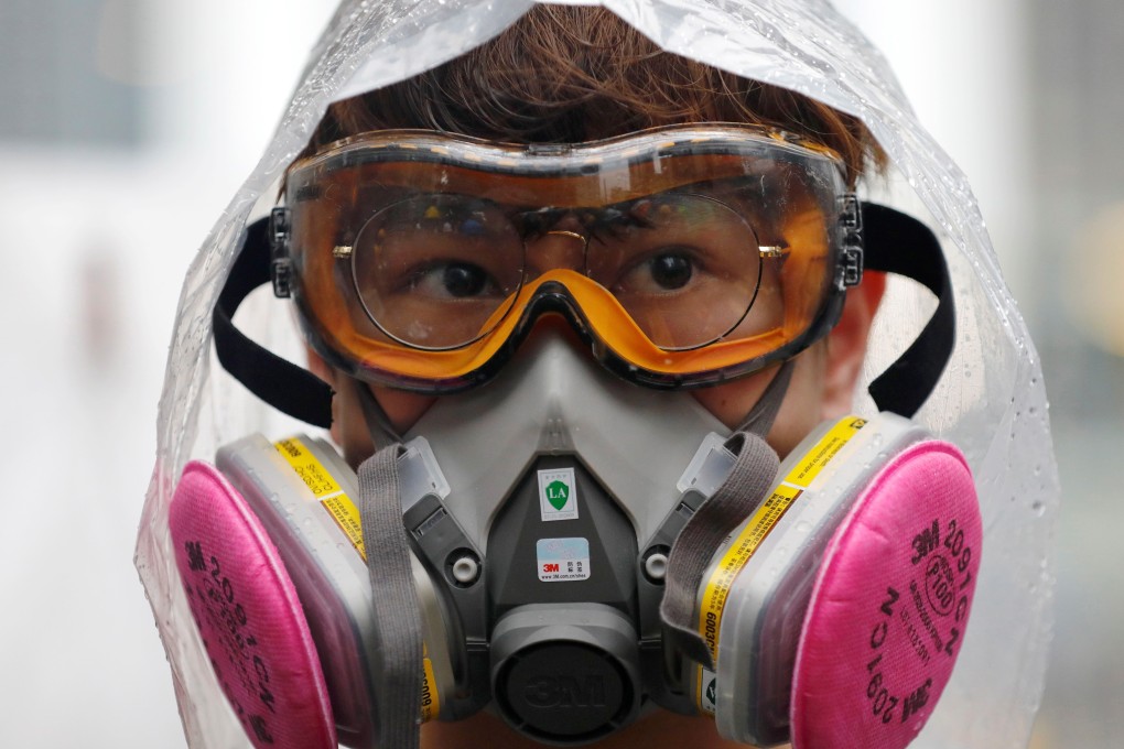 A gas-mask-clad protester faces down riot police during a protest on August 25. Photo: Reuters