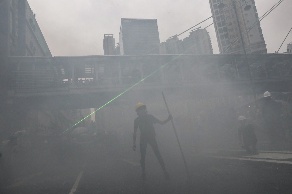 Protesters peer through tear gas during clashes with police in Tsuen Wan on August 25. Photo: Sam Tsang