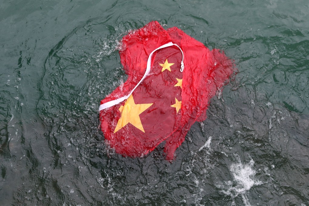 Anti-government protesters removed the Chinese flag from a flagpole in Tsim Sha Tsui and threw it into the sea on August 3. Photo: Sam Tsang
