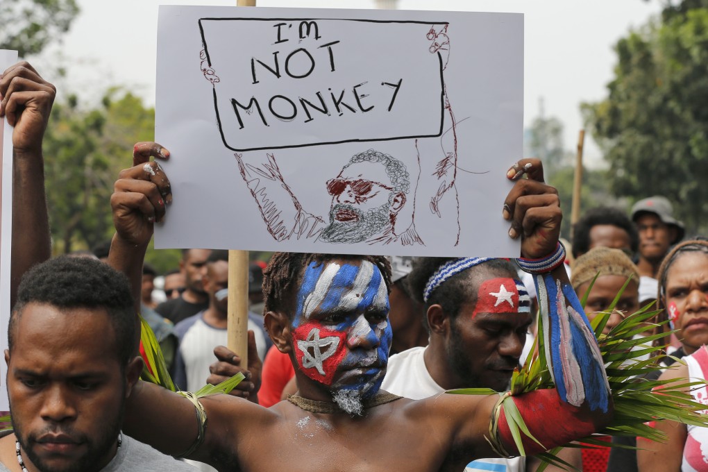 A Papuan student, whose face is painted with the colours of the separatist Morning Star flag, holds up a poster during a rally. Photo: AP