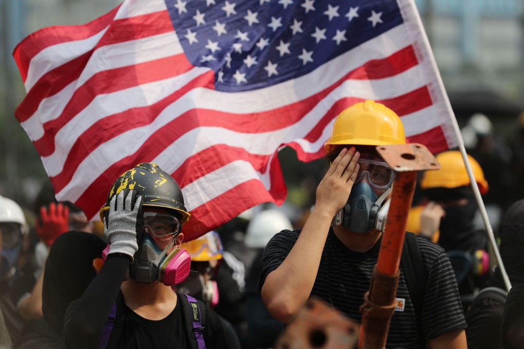 Protesters in the Ngau Tau Kok area of Hong Kong on August 24 wave the US flag, as others cover their right eye in tribute to a woman who suffered a serious eye injury during anti-government protests outside a police station two weeks before. Photo: Sam Tsang