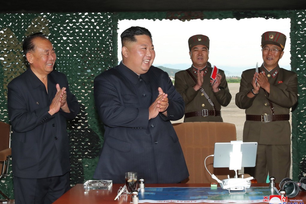 Kim Jong-un applauds as he watches a test firing of an unspecified missile on August 25. Photo: KCNA via AP